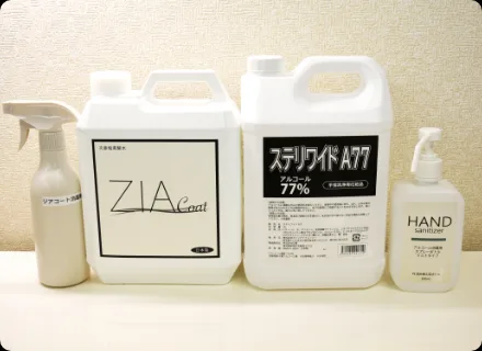 施術台に並べた消毒と除菌の資材。アルコール77%の容器とハンドサニタイザー